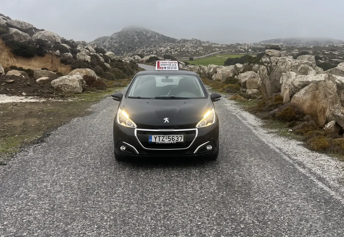 Το Peugeot της σχολής με αναμμένα φώτα σε δρόμο της Τήνου